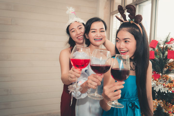Party concept, Portrait of young woman having fun while holding a glass of wine in Christmas party