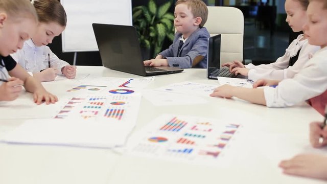 Young Children Sitting At Laptops In The Office