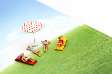 Obraz na płótnie Canvas Miniature people wearing swimsuit relaxing on book and world map background,holiday, vacation concept.