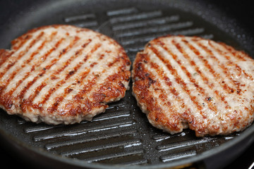 Grilled hamburger cutlets or burger patties on frying pan