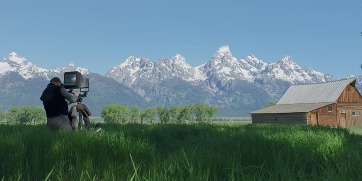 Man setting up large format camera in Grand Teton national park during sunny day