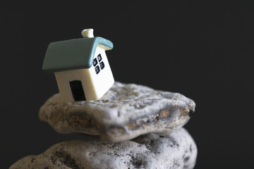 house on the edge of the abyss on a black background. The concept of a dangerous situation in life...