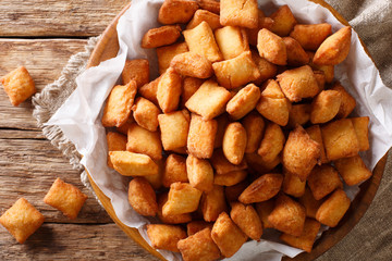 West African popular food: appetizer Chin Chin fried crispy dough close-up in a bowl. Horizontal top view