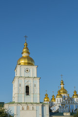 Fototapeta na wymiar Golden domes of St. Michael Cathedral in Kiev, Ukraine. St. Michael's Golden-Domed Monastery - famous church complex in Kiev, Ukraine. vertical photo