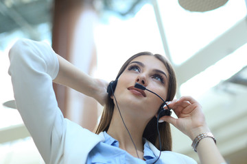 Call center operator in headset resting at workplace in office.