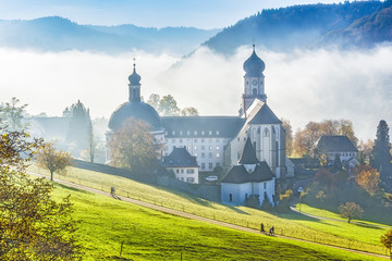 Scenic foggy mountain landscape with an old monastery in Black Forest, Germany. Colorful travel...