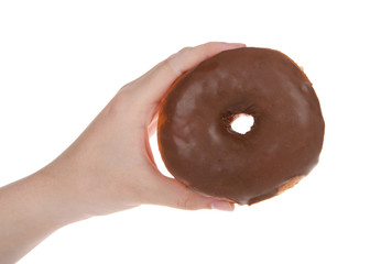 Young hand holding one chocolate glazed round donut isolated on white background.