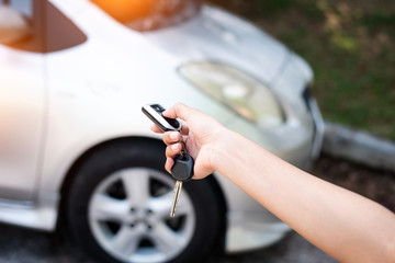 The human hand is pressing button on car remote control key,for open the car,warm light tone,blurry light around