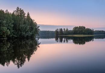 Scenic lake landscape with sunset and beautiful reflections at autumn evening in Finland.