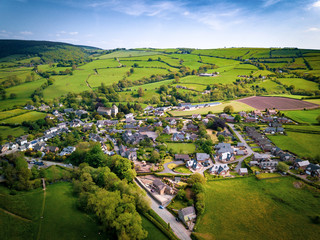 Aerial view above houses in an old British village in the countryside. Warm colours give a homely...