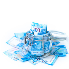 Paper Russian Money. New Russian Banknotes Of 2000 Two Thousands Rubles Close Up in glass jar on white isolated background. Saving money concept.