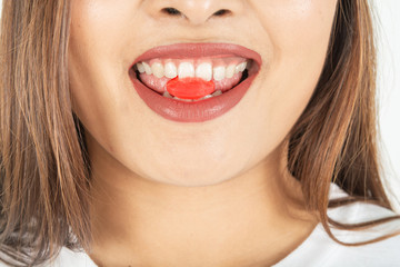 Red candy in the mouth and dark red lipstick of women