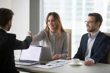 Businessman handshaking female business partner meeting in office ready for negotiations, diverse millennial colleagues shaking hand thanking for successful conference or talk. Partnership concept