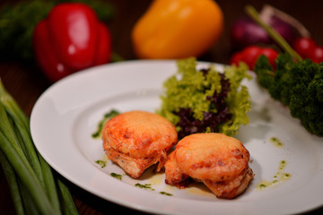 fish baked under cheese on a white plate