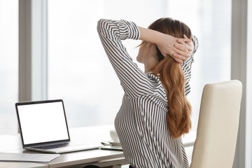 Office relax concept. Woman stretching with hands behind her head in ergonomic office chair after...