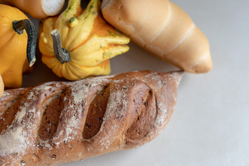 Bread and pumpkins on textured light background