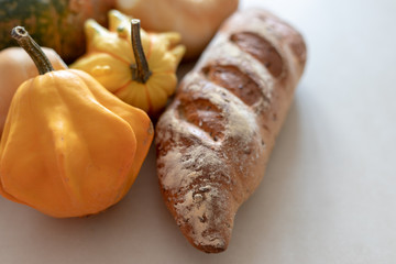 Bread and pumpkins on textured light background