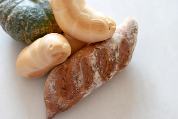 Bread and pumpkins on textured light background