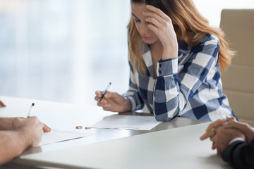 Serious millennial wife sign decree paper filing for divorce with husband visiting lawyer office,...