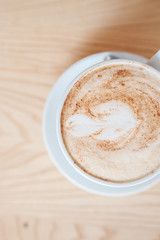 Cup with a fragrant cappuccino on a wooden background