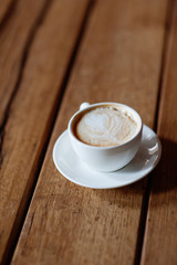 Cup with a fragrant cappuccino on a wooden background