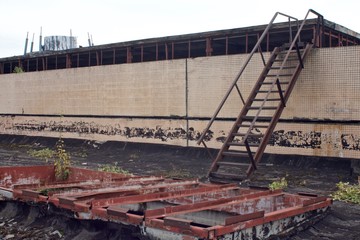 rusty stairs on the roof of an old abandoned industrial building