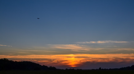 Fototapeta na wymiar Beautiful sunset in the field. Red, yellow, blue sky. Summer evening.