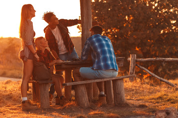 Fototapeta premium Group of four hikers sitting and resting after hiking in countryside.