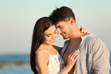 Obraz premium Happy young couple posing near sea on beach