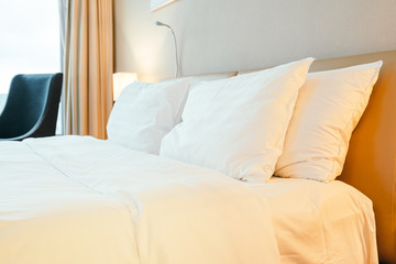 Fototapeta na wymiar White pillow on bed decoration in bedroom interior