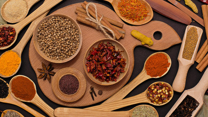 Spice. Spice in a wooden spoon. Herbs. Curry, saffron, turmeric, pepper and others on a black background.