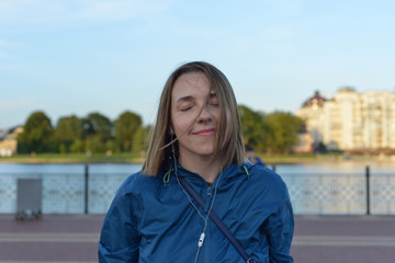 Portrait of a natural woman wearing headphones on the street