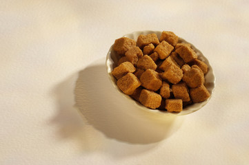 BROWN SUGAR CUBES IN WHITE BOWL