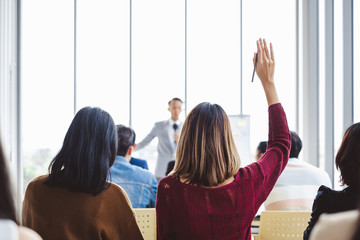 Business woman raising hand for asking speaker for question and answer concept in meeting room for seminar