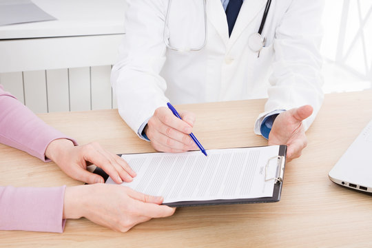 doctor discusses with female patient medical contract at the clinic, medical insurance