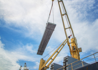 plate of steel slab being lifting handle by the ship crane, loading discharging operation for transfer the cargo shipment in export and import