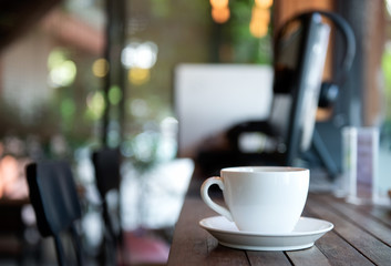 White coffee cup on wooden floor in cafe.