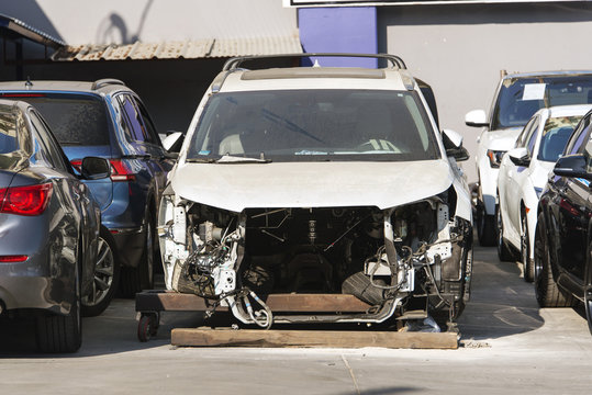 Front view of a crashed and damaged car in a parking lot 