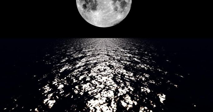 White colored moon setting slowly over the ocean at night.