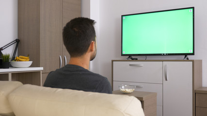 Man playing with joystick while sitting in his couch. Relaxing time