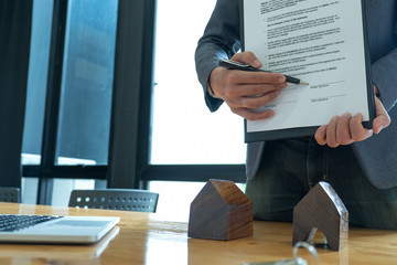 Pen in hand businessman pointing at document signing.
