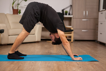 Adult man doing Dolphin yoga pose in his workout routine. Healthy workout.