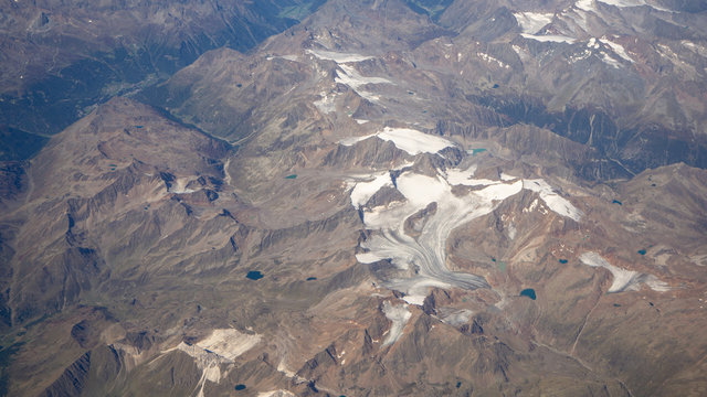 Fototapeta Flying over the European Alps during summer season. Landscape at the glaciers. Aerial view from the airplane window