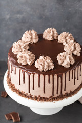 Cake with coffee cheese cream and chocolate topping on a white cake stand