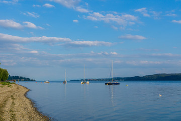 Silent lake with anchoring boats in evening atmosphere