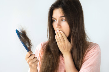 Young woman is upset because of hair loss