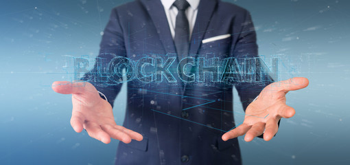 Businessman holding a Blockchain title isolated on a background