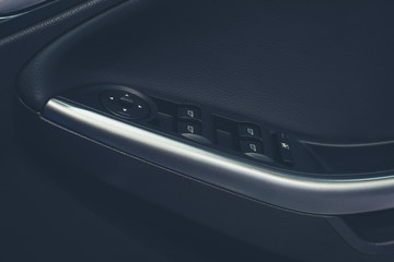 Obraz na płótnie Canvas Modern Car door interior armrest with window control panel, door lock button. Interior details.