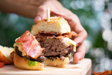 Hamburgers and French fries on the wooden tray.