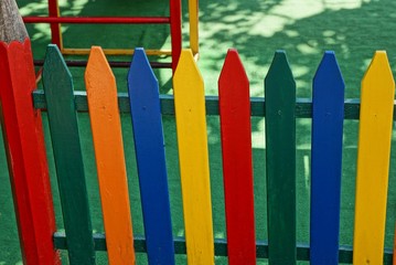 colored decorative fence from boards at a children playground